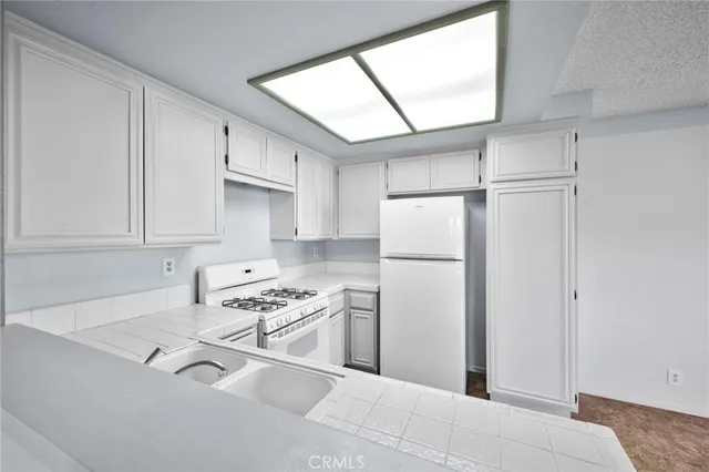 a kitchen with white cabinets and white appliances
