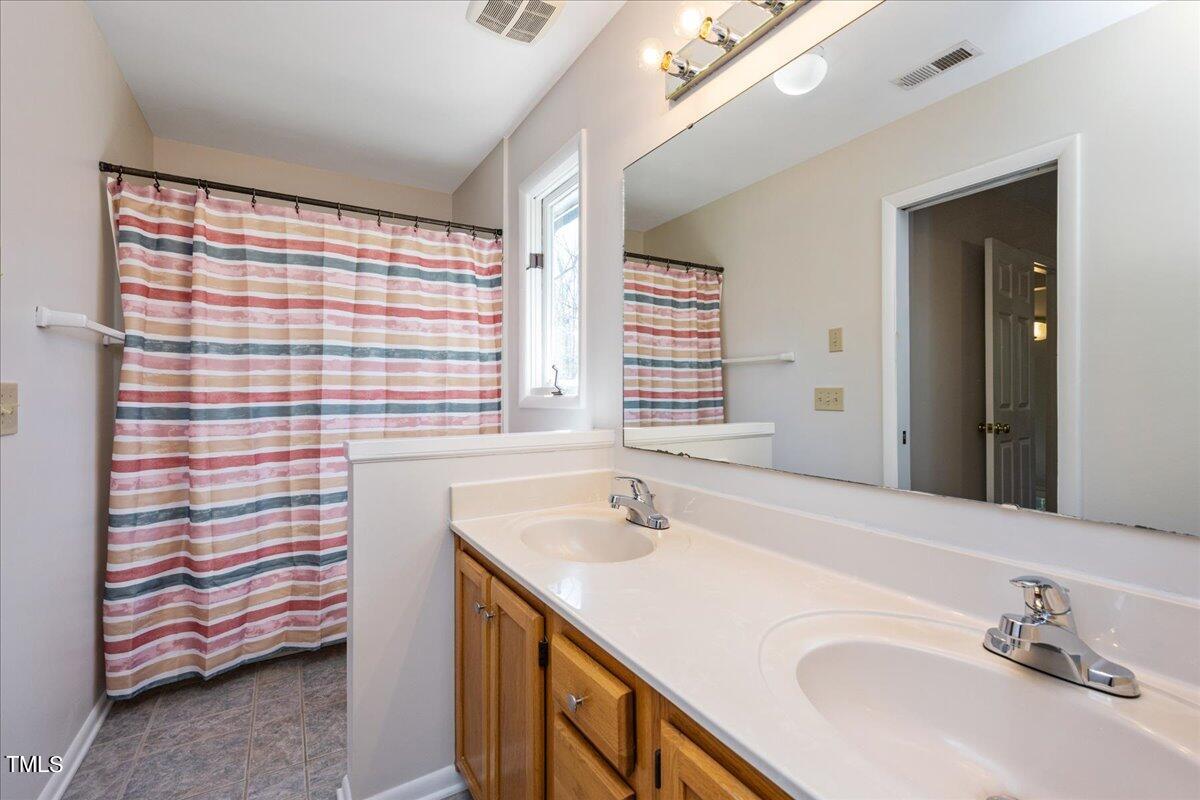 4201 Loon Lane Raleigh, NC 27616 - Photo 15 of 31 a bathroom with a sink double vanity and a shower