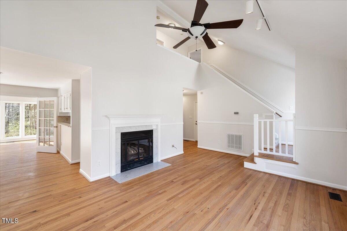 4201 Loon Lane Raleigh, NC 27616 - Photo 5 of 31 a view of a livingroom with wooden floor a fireplace and windows