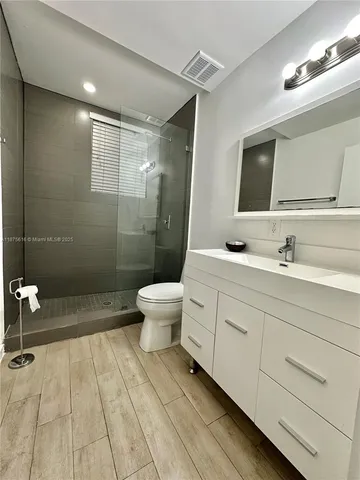a bathroom with a double vanity sink toilet and shower