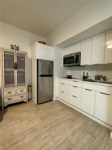 a kitchen with stainless steel appliances a refrigerator sink and microwave
