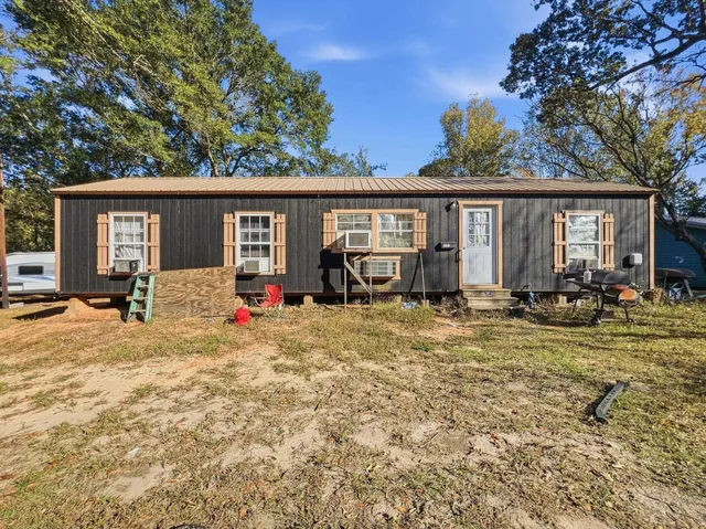 a view of a house with backyard and a tree