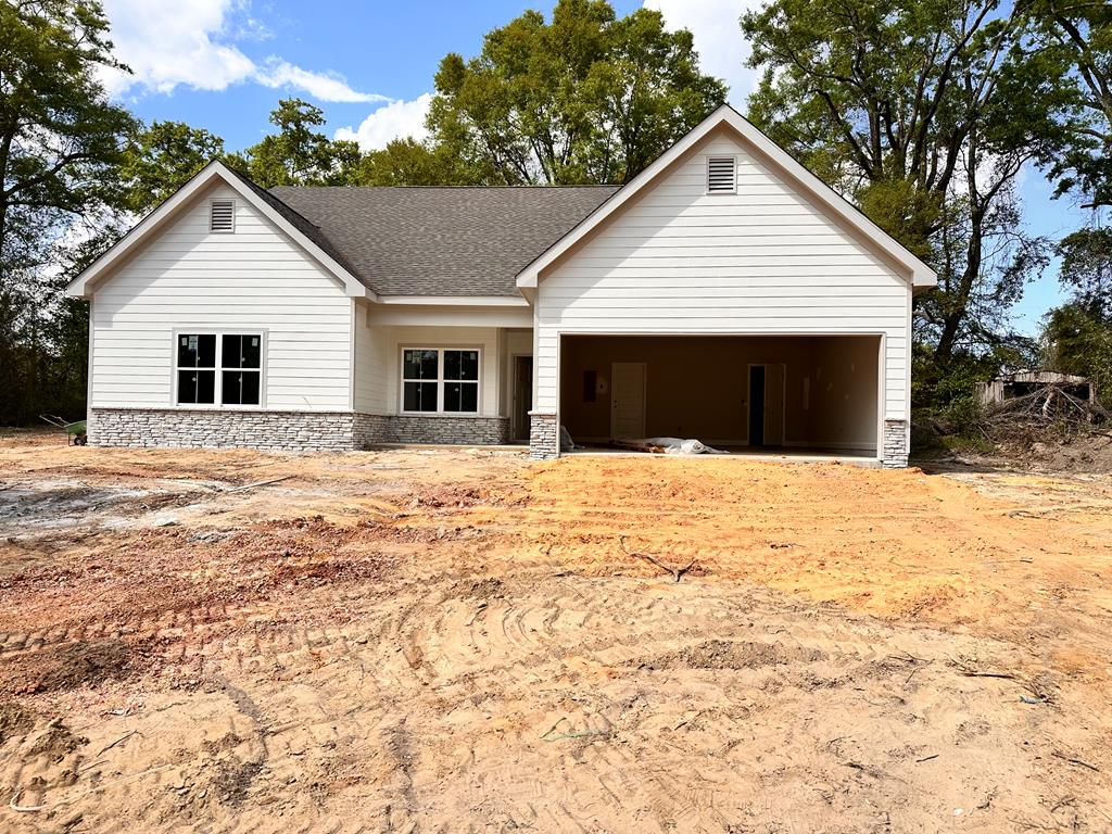 a view of house with yard and sitting area