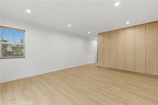 a spacious bedroom with a bed a couch and a window