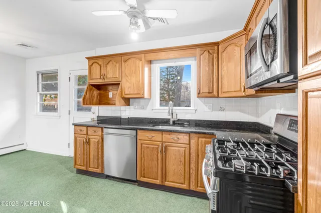 a kitchen with stainless steel appliances granite countertop a stove a sink and a microwave