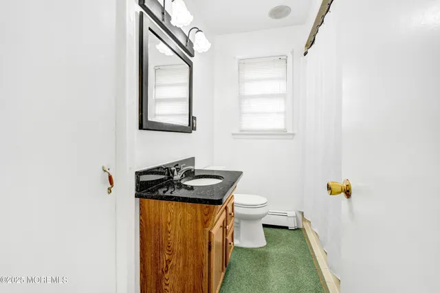 a bathroom with a toilet sink and mirror