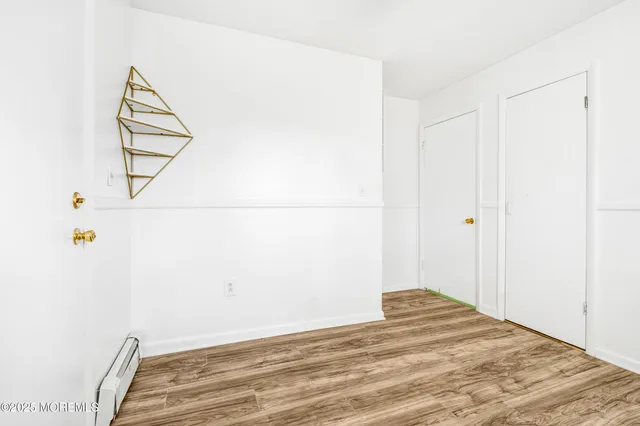 a view of a room with wooden floor and white walls