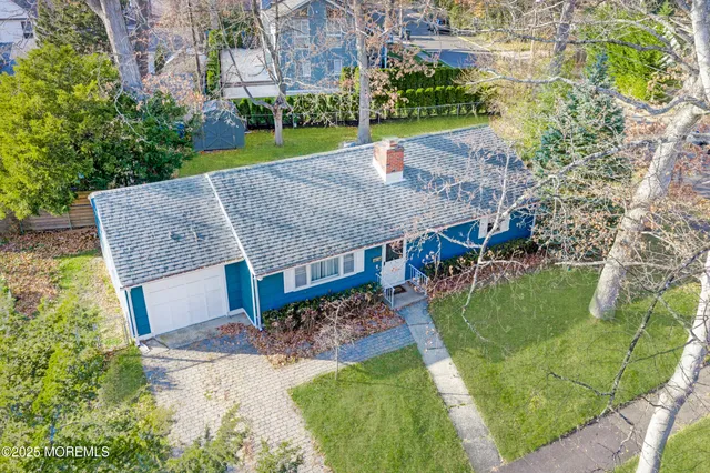 a view of a white house with a big yard and large trees