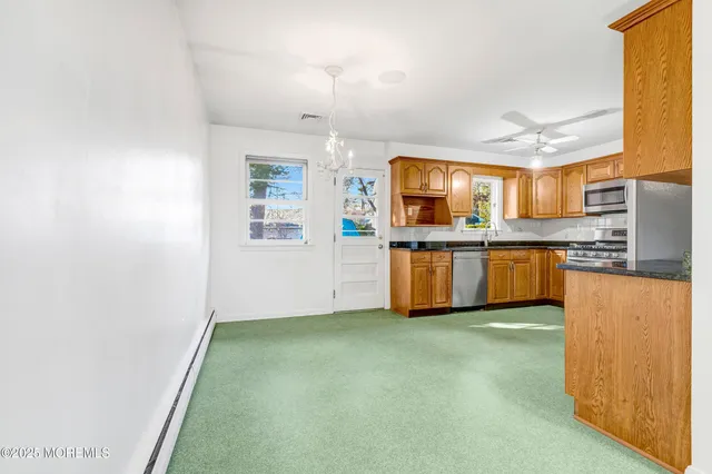 a kitchen with stainless steel appliances granite countertop a refrigerator and a stove top oven