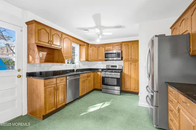 a kitchen with stainless steel appliances granite countertop a refrigerator and a stove top oven