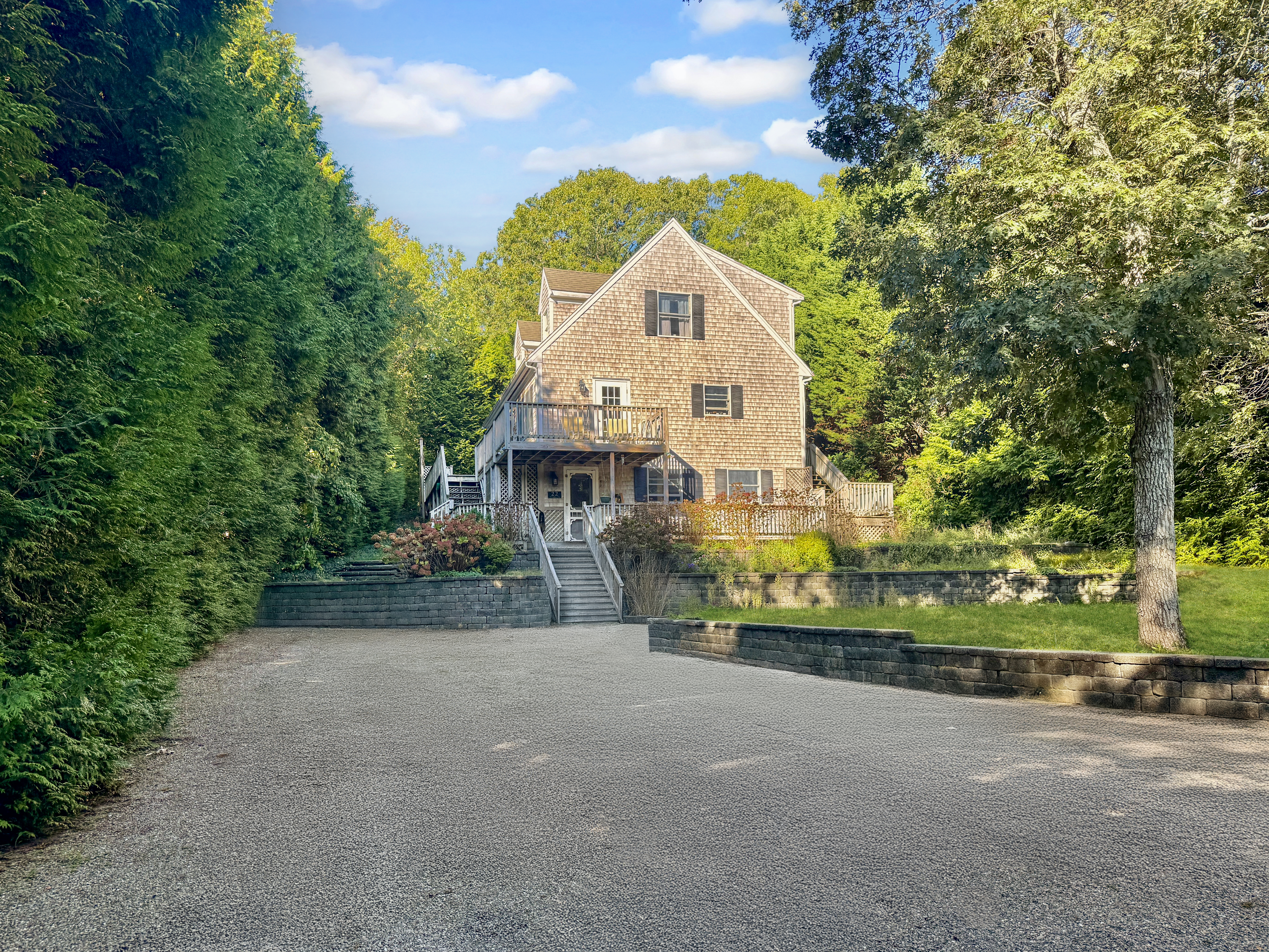 a view of a house with a small yard and a large tree