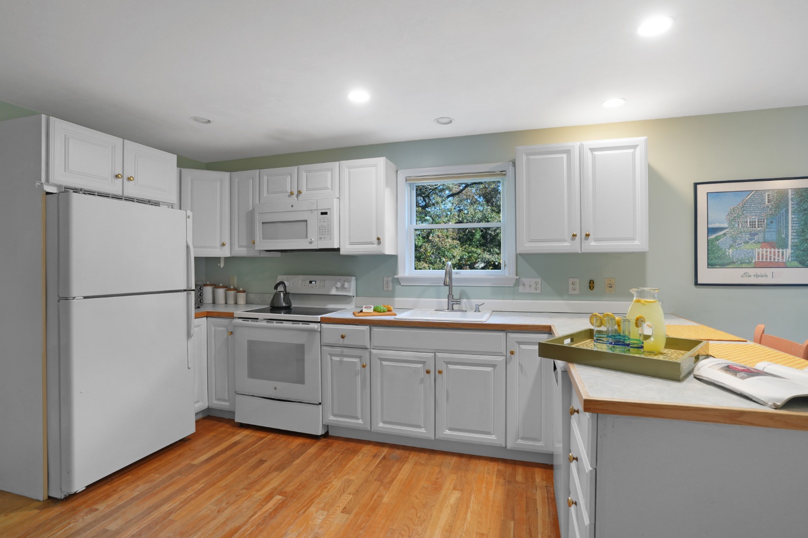 22 Old Lighthouse Road Vineyard Haven, MA 02568 - Photo 6 of 26 a kitchen with stainless steel appliances granite countertop a refrigerator sink and white cabinets