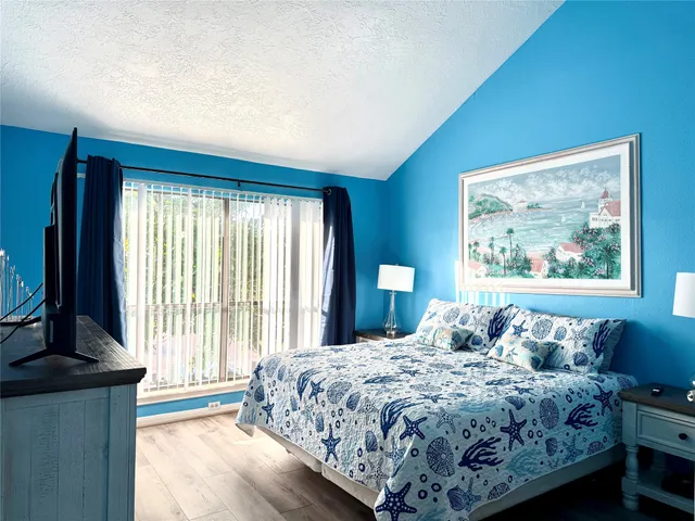 a bedroom with a bed and a painting on the wall