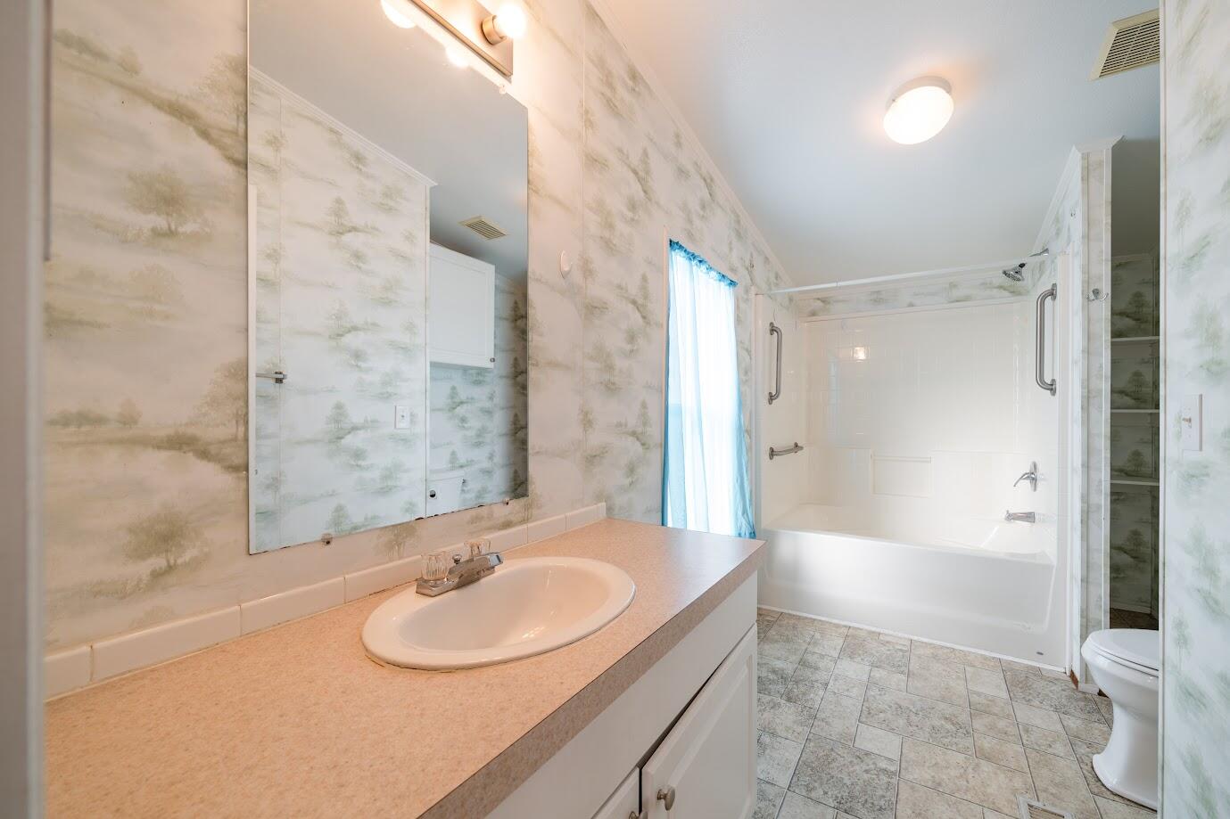 2016 Westerly Drive Rosamond, CA 93560 - Photo 16 of 20 a bathroom with a granite countertop sink a toilet and shower