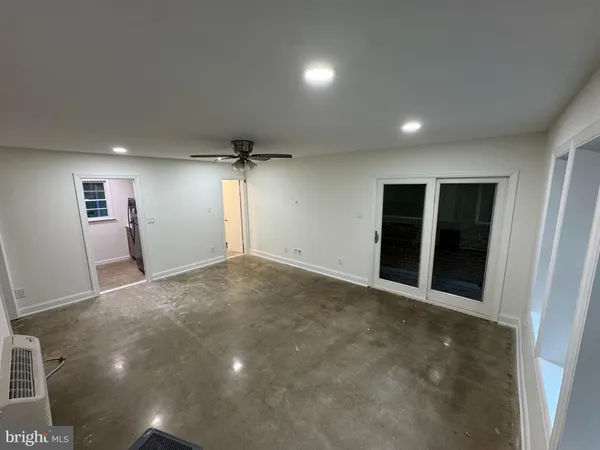 an empty room with windows and cabinet