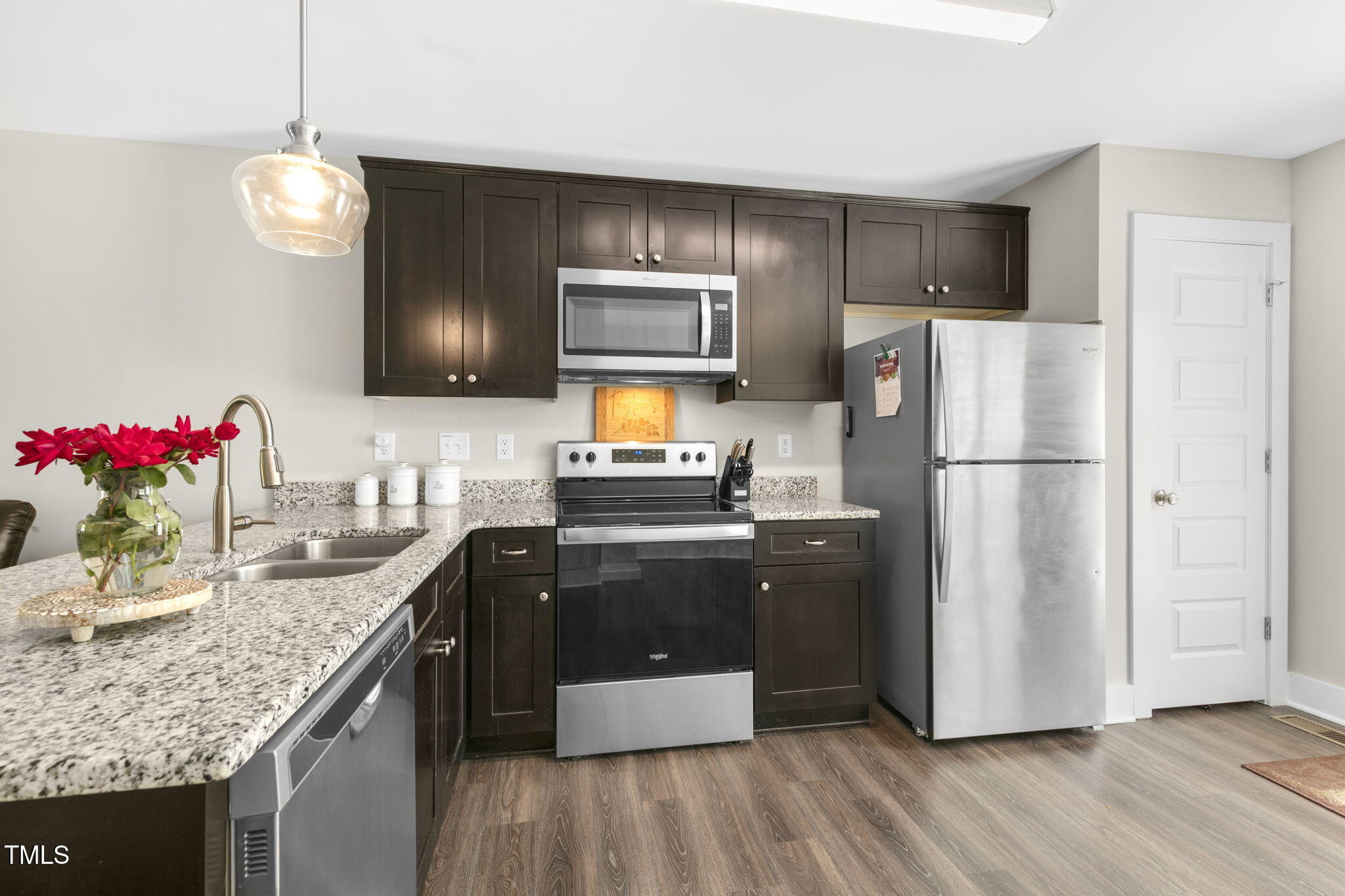 355 South Church Street Coats, NC 27521 - Photo 10 of 29 a kitchen with granite countertop stainless steel appliances a refrigerator microwave and stove top oven