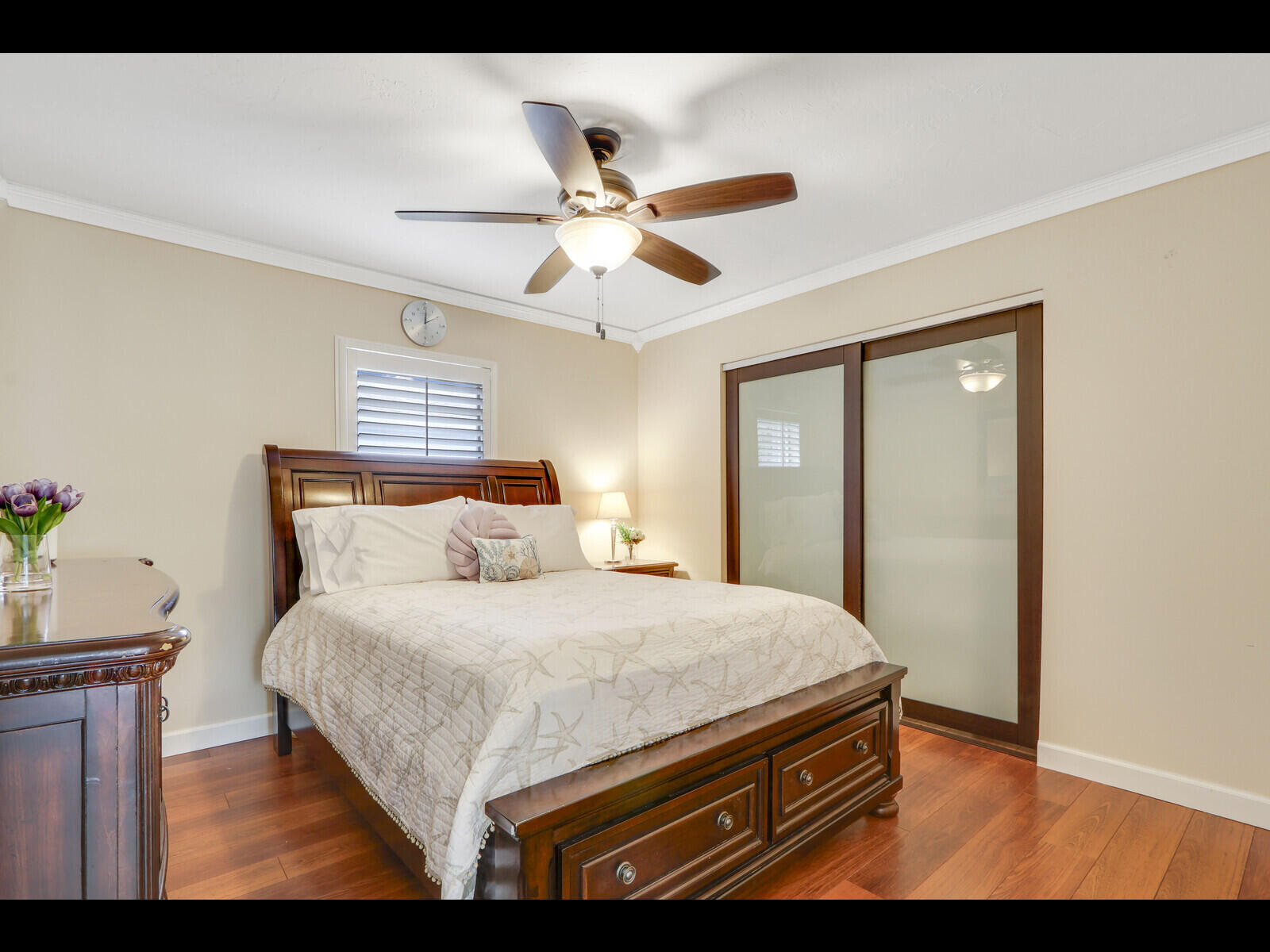 609 Oak Terrace Jupiter, FL 33458 - Photo 17 of 28 a bedroom with a bed and a chandelier