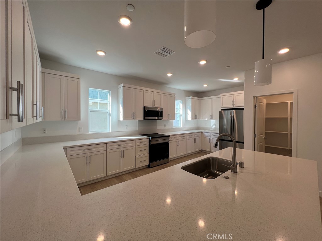 2544 Dorris Street El Monte, CA 91733 - Photo 3 of 13 a large kitchen with kitchen island a sink stainless steel appliances and cabinets