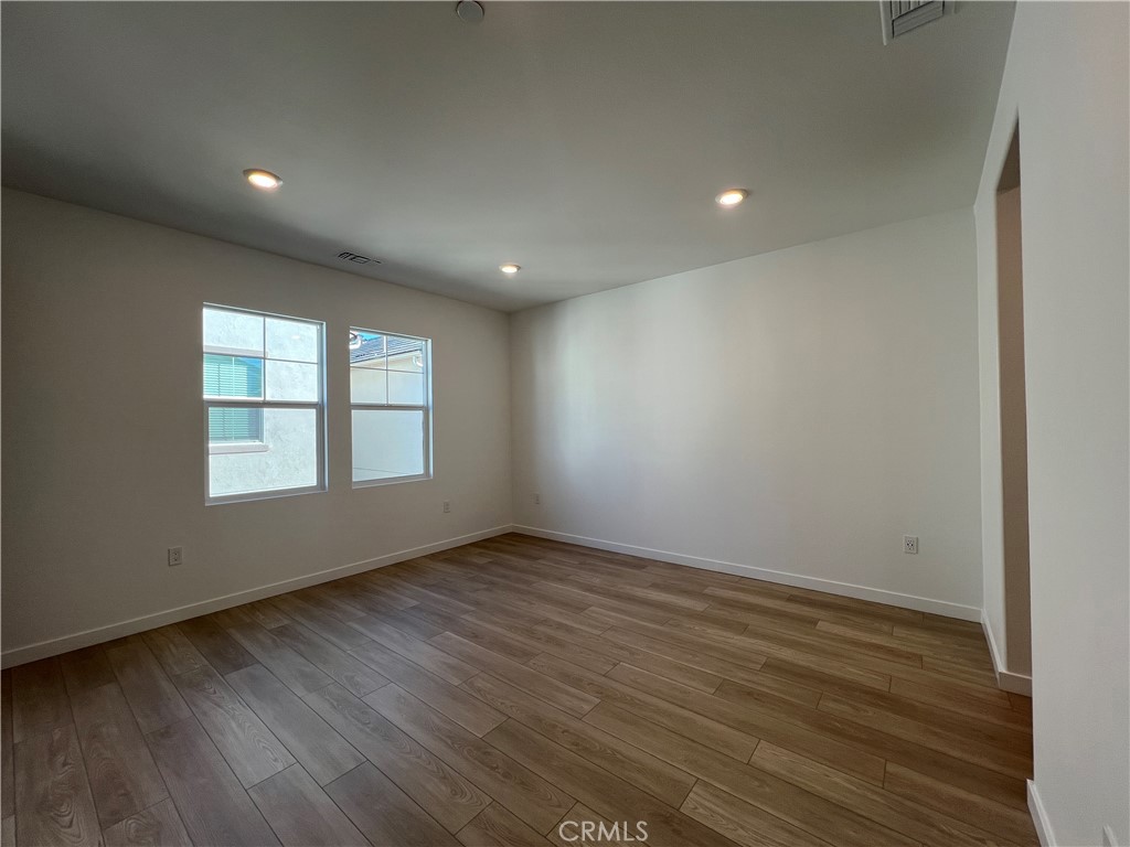 2544 Dorris Street El Monte, CA 91733 - Photo 10 of 13 an empty room with wooden floor and windows