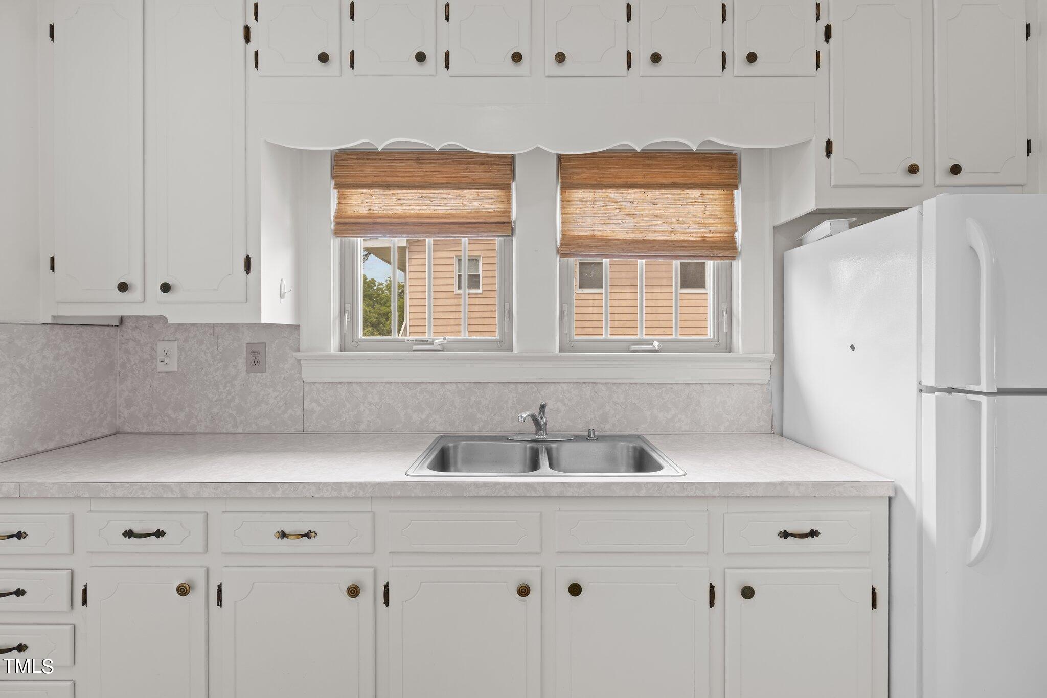 501 South Main Street Roxboro, NC 27573 - Photo 14 of 30 a kitchen with stainless steel appliances white cabinets and a window