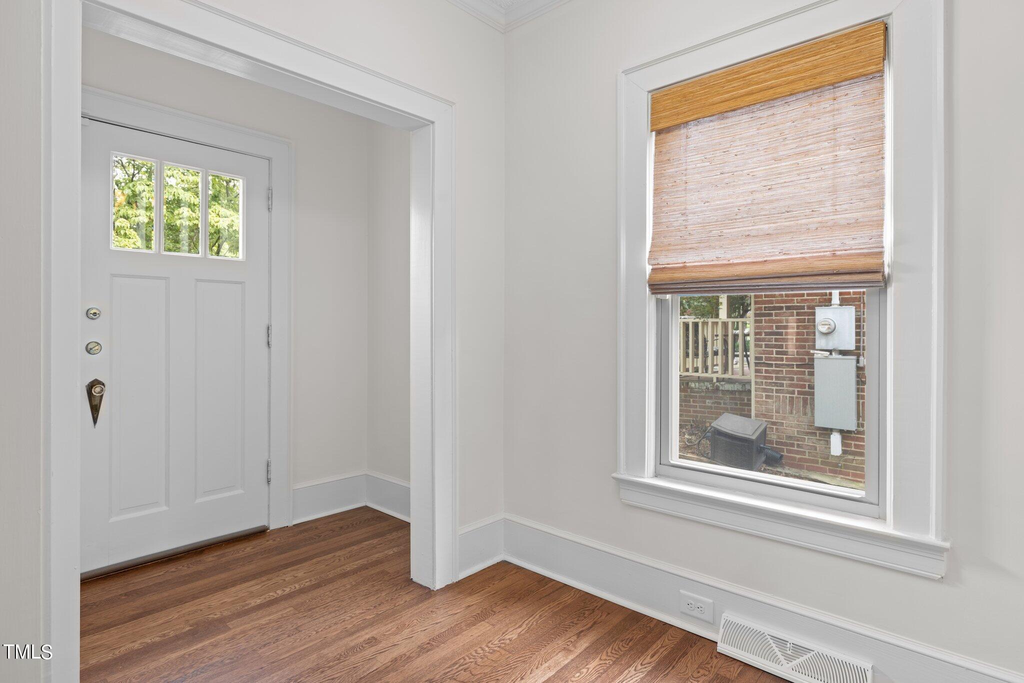 501 South Main Street Roxboro, NC 27573 - Photo 4 of 30 an empty room with wooden floor and windows