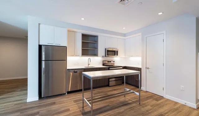 a kitchen with stainless steel appliances granite countertop a refrigerator stove a sink and dishwasher