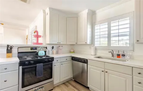 a kitchen with white cabinets and appliances