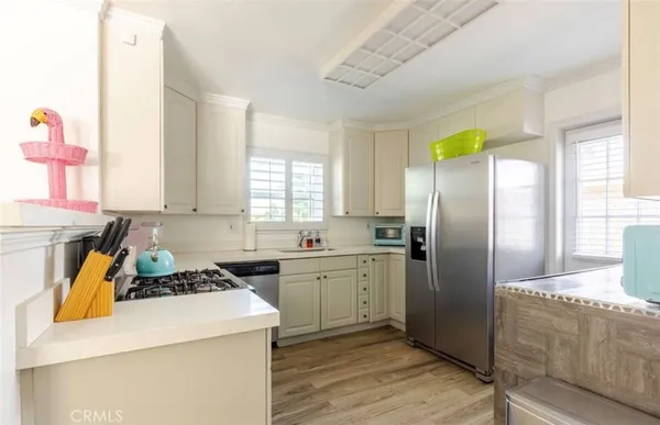 a kitchen with a refrigerator a stove a sink and cabinets