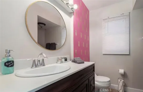 a bathroom with a sink mirror vanity and toilet