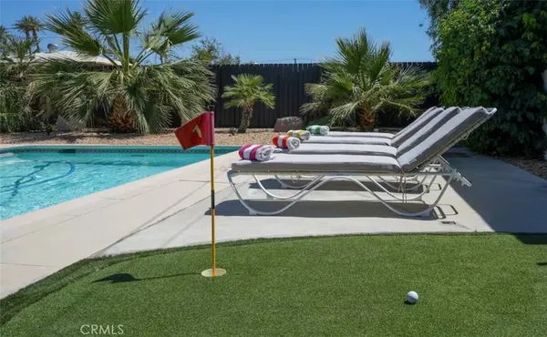 a white bench sitting in the grass near a yard