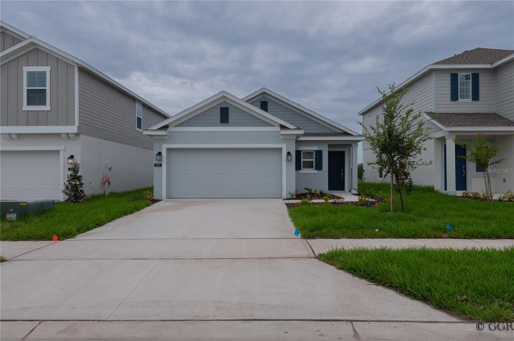 a front view of a house with a yard and a garage