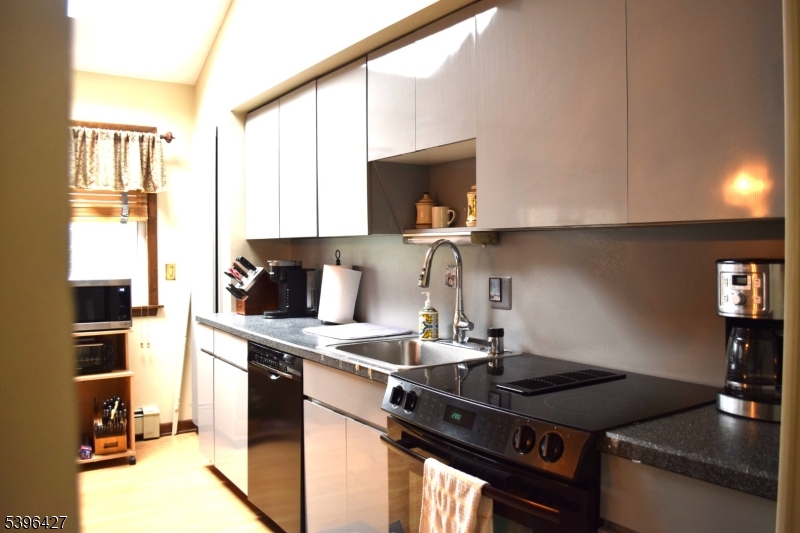 27 3rd Avenue Roseland, NJ 07068 - Photo 10 of 16 a kitchen with granite countertop a sink stove and cabinets