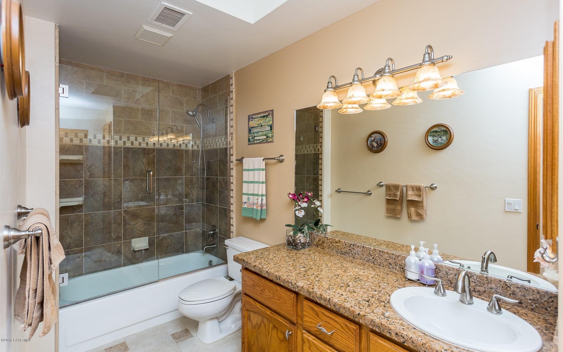 1631 Kaibab Loop Prescott, AZ 86303 - Photo 19 of 45 a bathroom with a granite countertop sink a toilet a mirror and shower