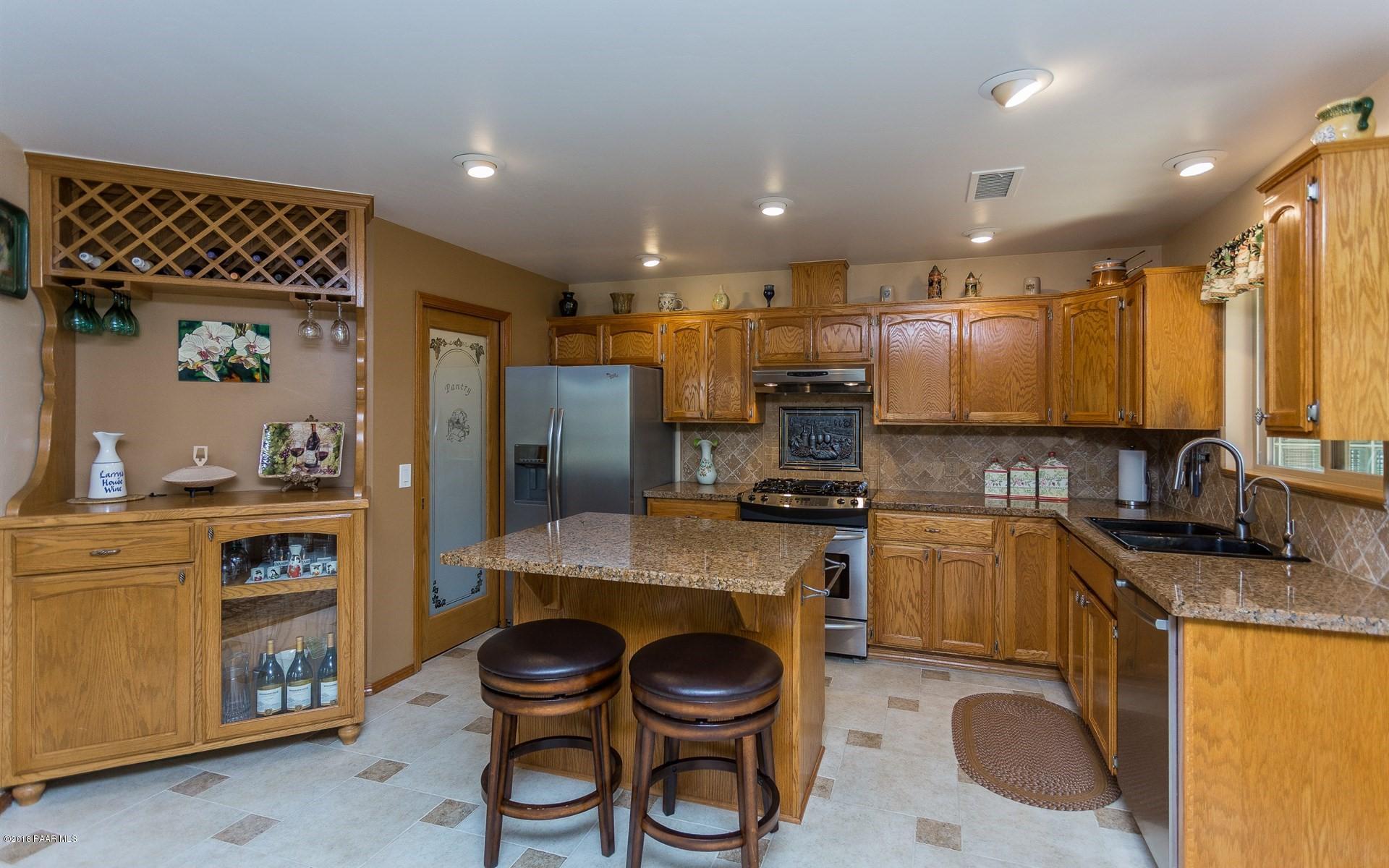 1631 Kaibab Loop Prescott, AZ 86303 - Photo 10 of 45 a kitchen with stainless steel appliances a sink a stove a refrigerator cabinets and a dining table