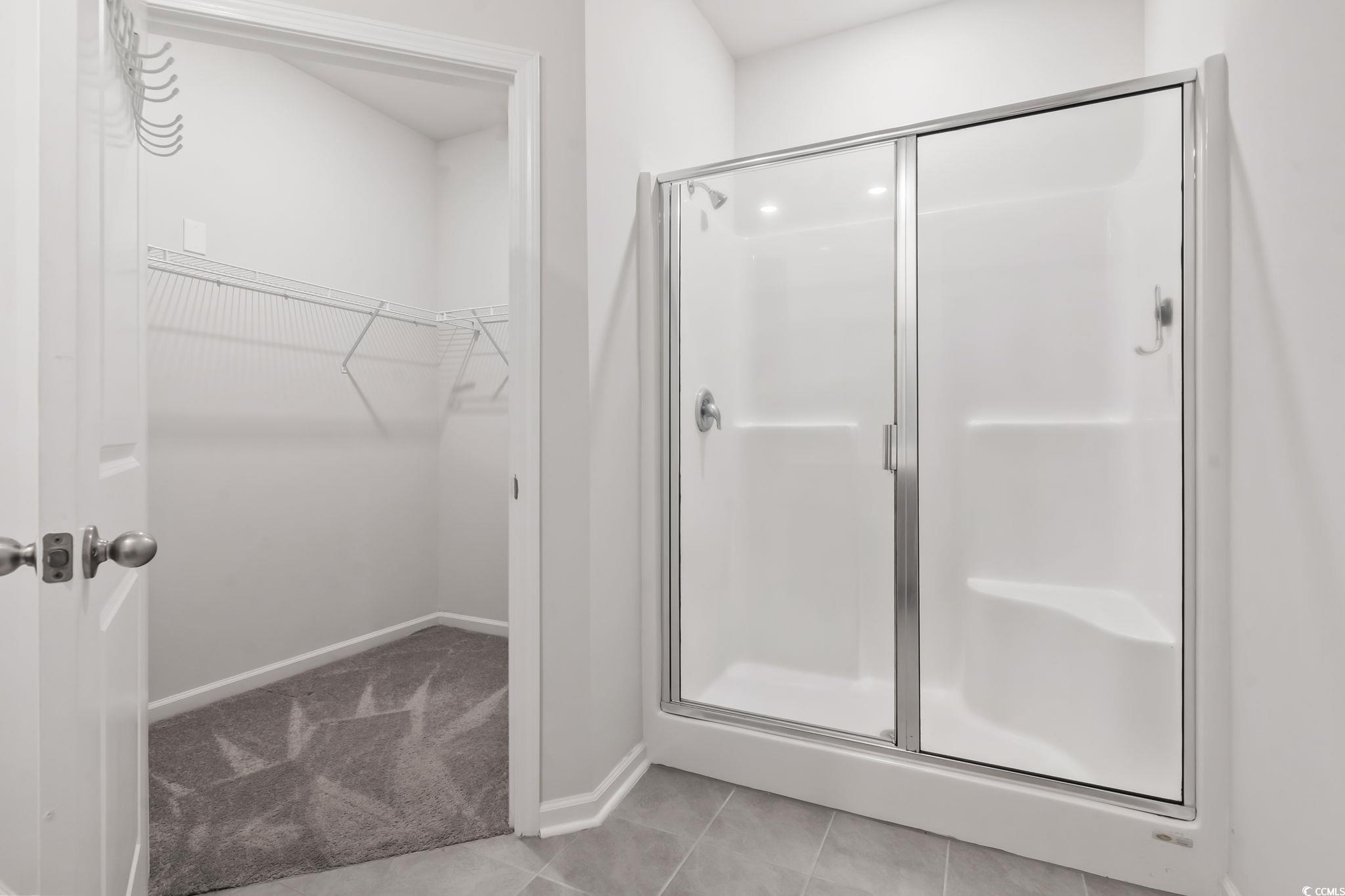 62 Sea Shell Drive, Unit 62 Murrells Inlet, SC 29576 - Photo 17 of 34 Bathroom with a stall shower, a spacious closet, and tile patterned floors
