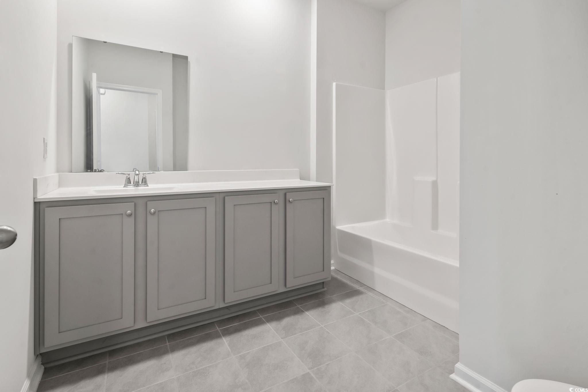 62 Sea Shell Drive, Unit 62 Murrells Inlet, SC 29576 - Photo 23 of 34 Bathroom with vanity, tile patterned floors, and washtub / shower combination