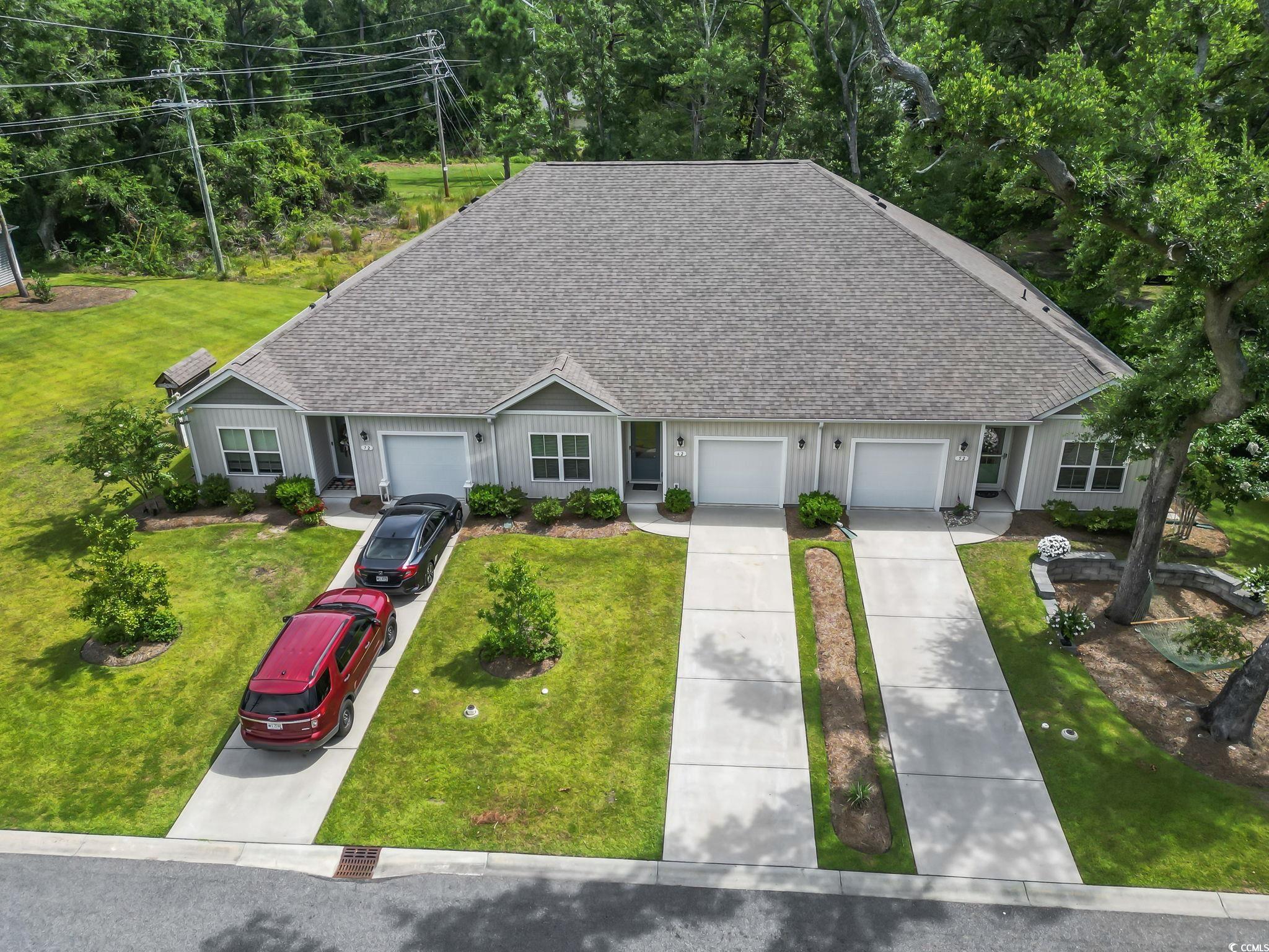 62 Sea Shell Drive, Unit 62 Murrells Inlet, SC 29576 - Photo 29 of 34 Single story home featuring a shingled roof, board and batten siding, driveway, and a front yard