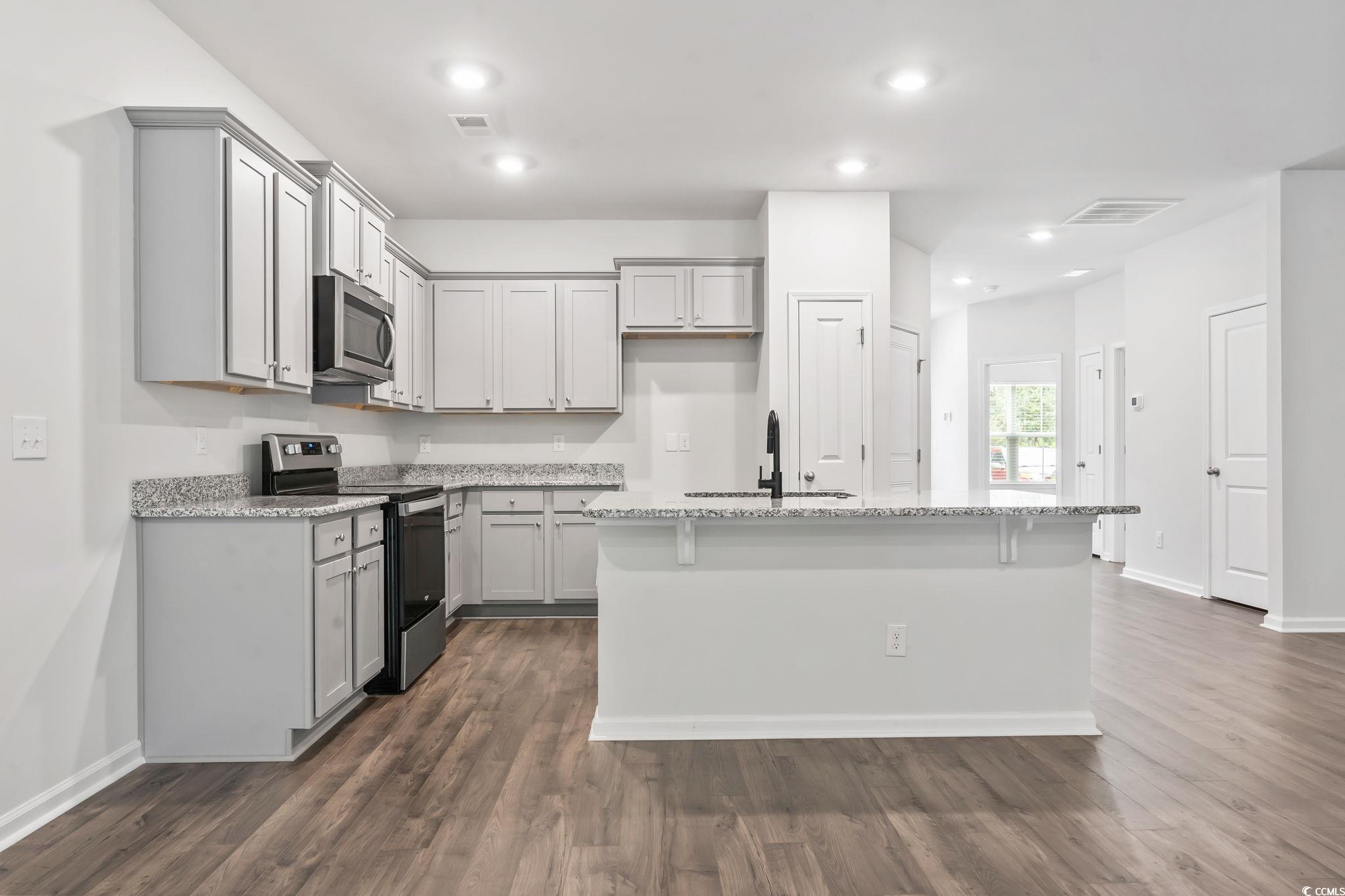 62 Sea Shell Drive, Unit 62 Murrells Inlet, SC 29576 - Photo 31 of 34 Kitchen with appliances with stainless steel finishes, gray cabinets, light stone countertops, dark wood-style flooring, and recessed lighting