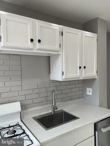 a kitchen with white cabinets and white appliances