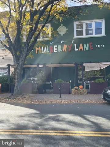 a view of a building with a space and a car parked on the road