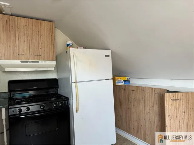 a white refrigerator freezer and a stove sitting inside of a kitchen