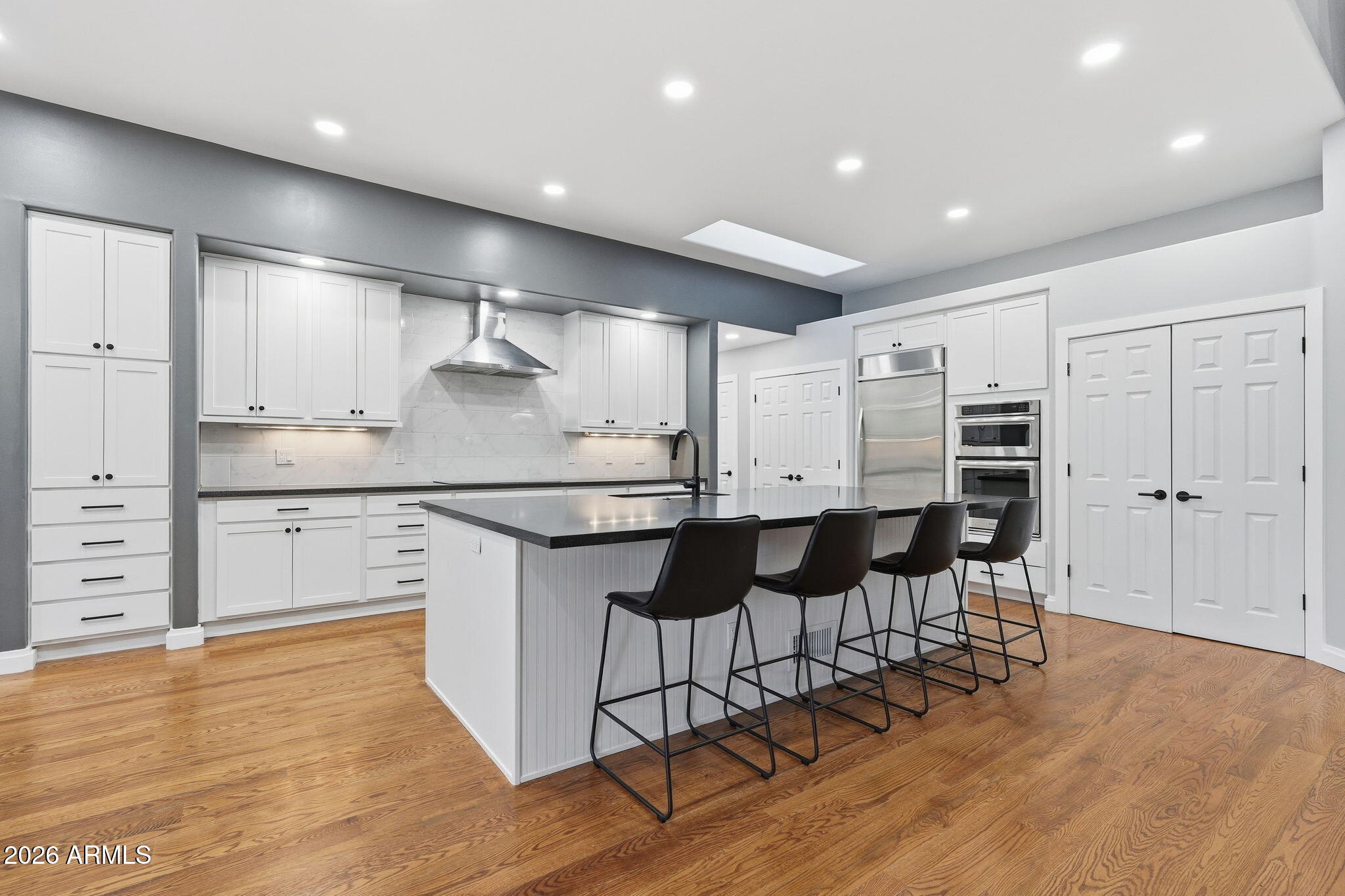 3441 Griffiths Spring Flagstaff, AZ 86005 - Photo 20 of 71 a kitchen with stainless steel appliances kitchen island granite countertop a stove a refrigerator and white cabinets with wooden floor