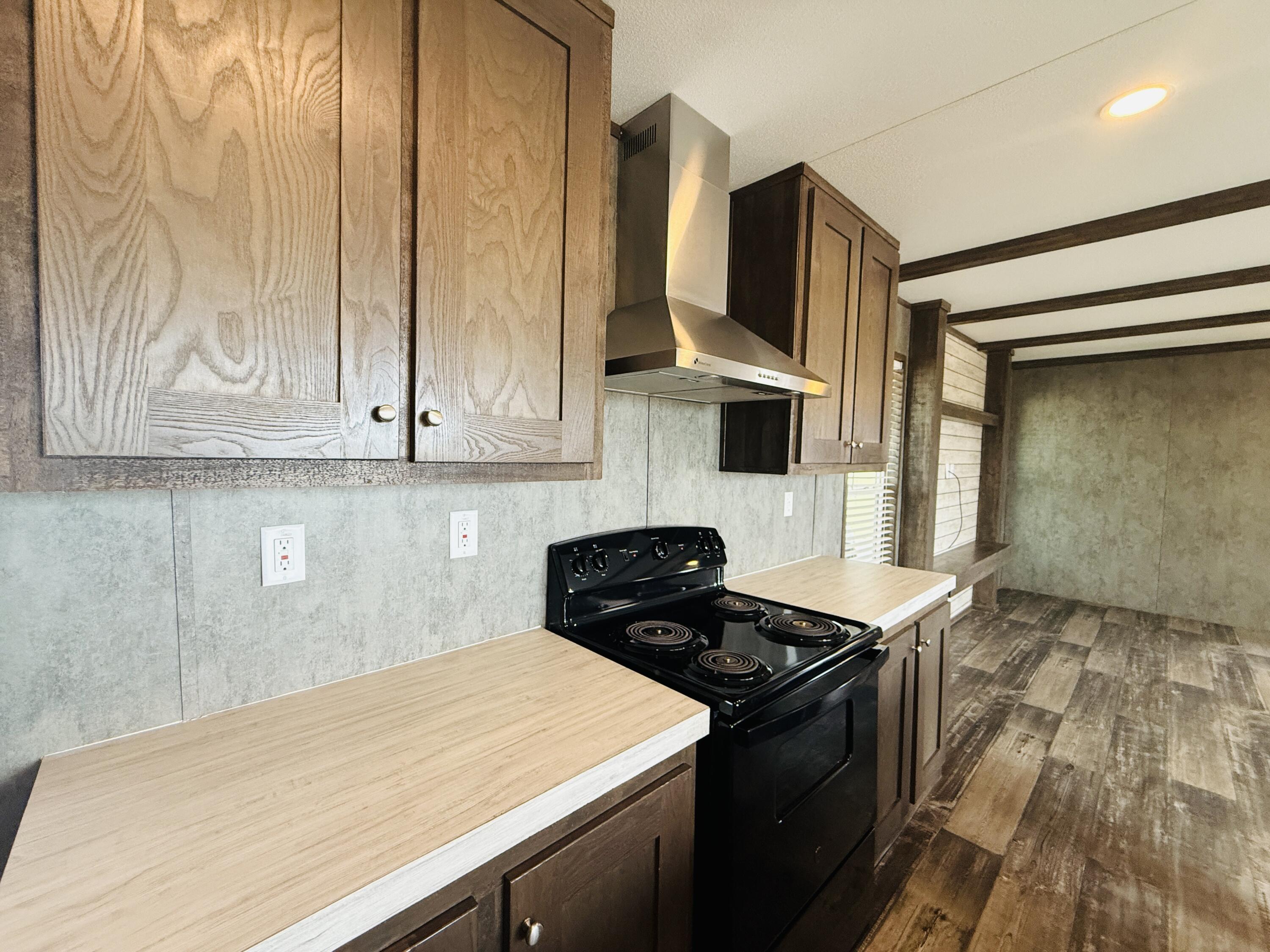 365 Private Road 211 Road North Seminole, TX 79360 - Photo 11 of 22 a kitchen with a stove and a white cabinet with wooden floor