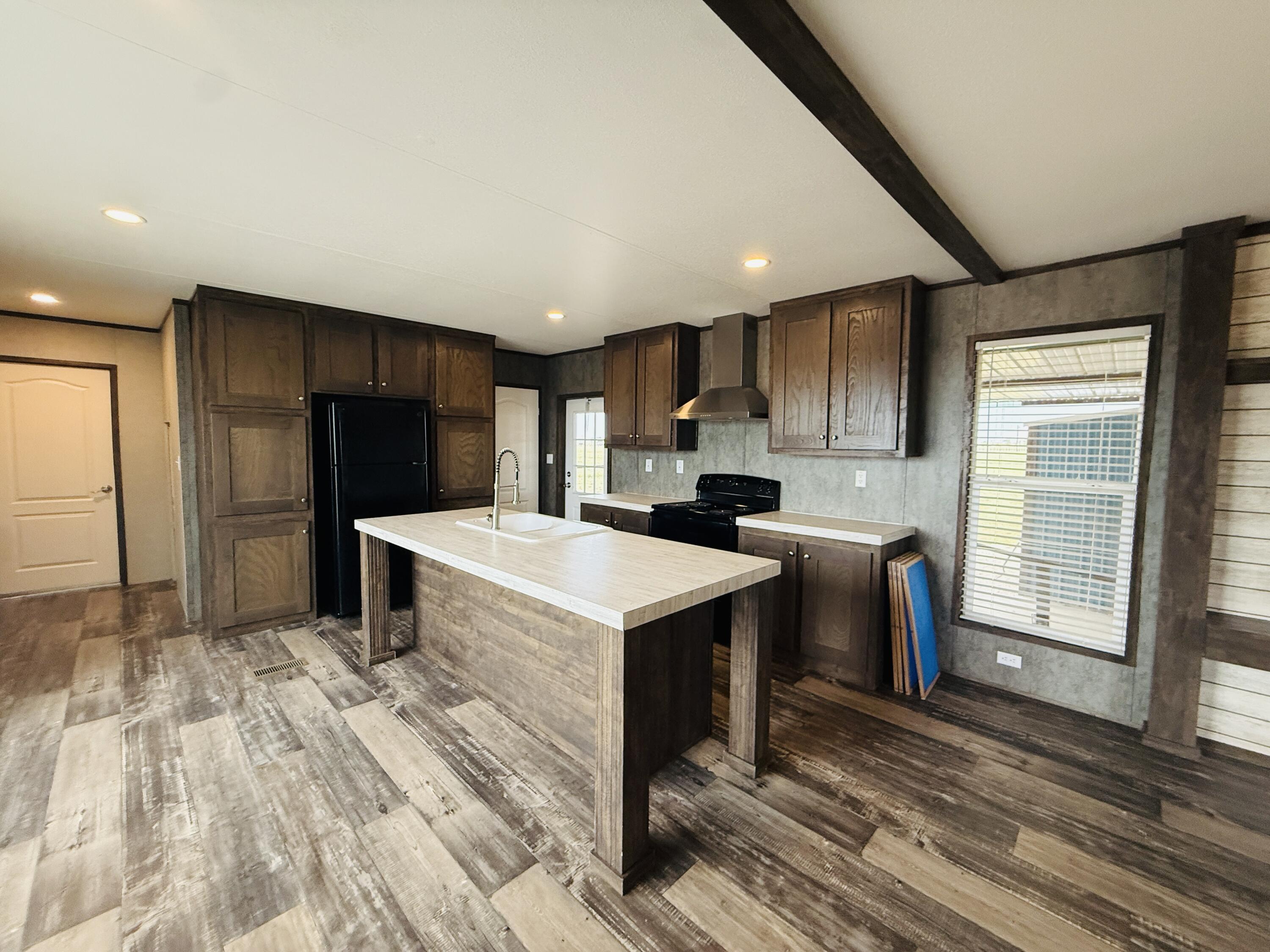 365 Private Road 211 Road North Seminole, TX 79360 - Photo 7 of 22 a kitchen with stainless steel appliances kitchen island granite countertop a refrigerator and a stove top oven