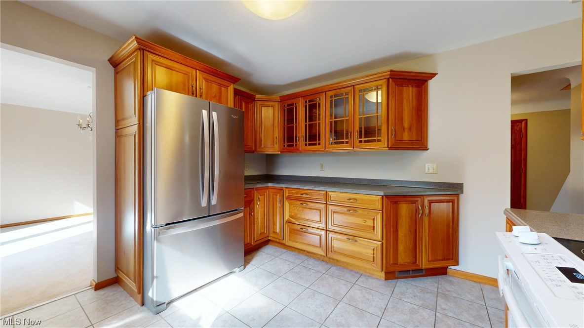 11110 Kile Road Chardon, OH 44024 - Photo 18 of 35 Kitchen with light tile flooring, stainless steel refrigerator, and a notable chandelier