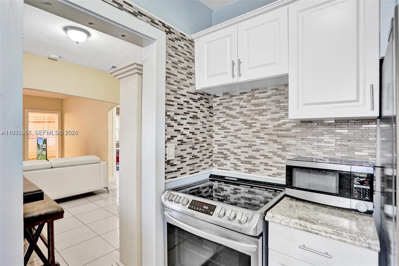 1868 Northwest 64th Street Miami, FL 33147 - Photo 11 of 21 a kitchen with a stove and a white cabinet