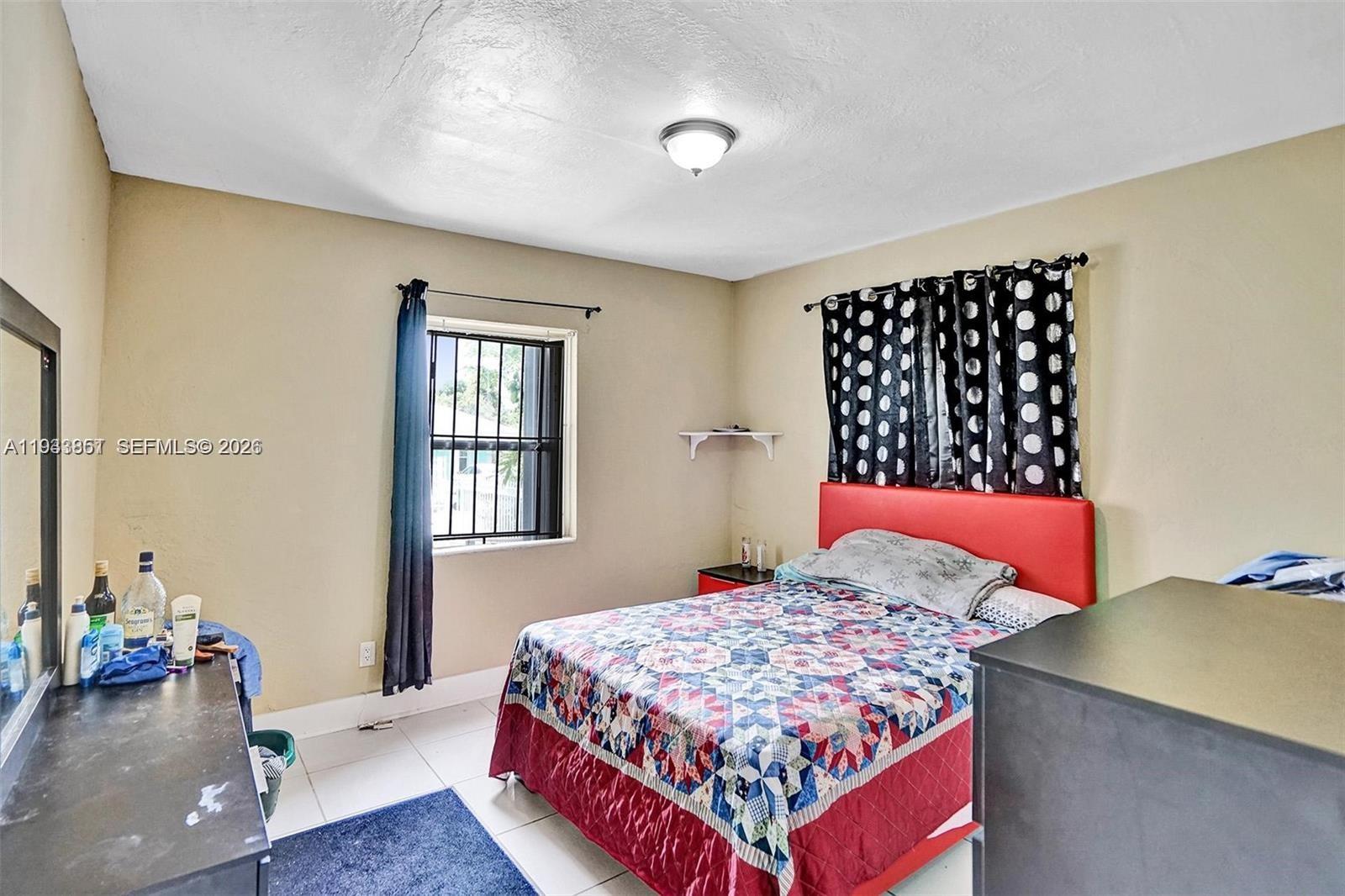 1868 Northwest 64th Street Miami, FL 33147 - Photo 13 of 21 a bedroom with a bed and wooden floor