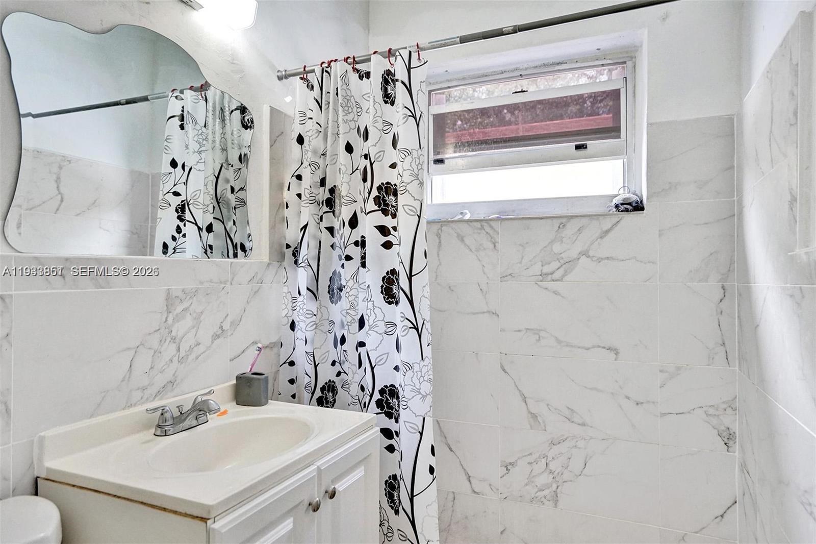 1868 Northwest 64th Street Miami, FL 33147 - Photo 15 of 21 a bathroom with a sink and a mirror