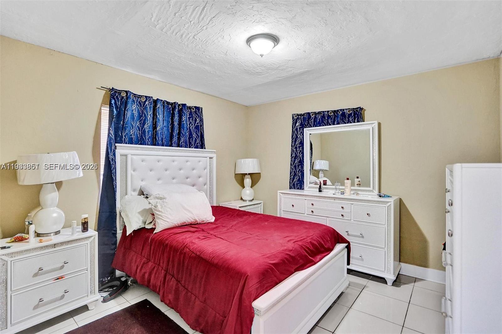 1868 Northwest 64th Street Miami, FL 33147 - Photo 17 of 21 a bedroom with a bed and a dresser in it