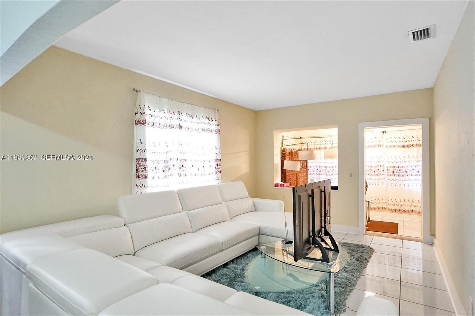 1868 Northwest 64th Street Miami, FL 33147 - Photo 5 of 21 a living room with furniture a large window and a rug
